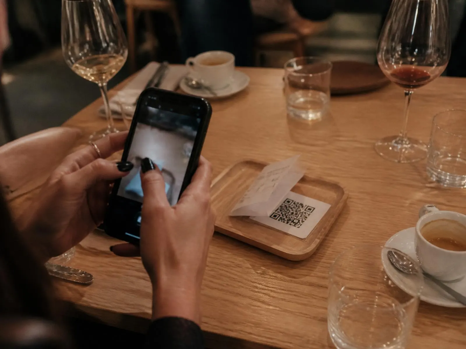 Waiter placing the bill with a QR code on a restaurant table